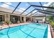 Inviting screened pool with outdoor kitchen and plenty of patio space for entertaining and relaxation at 2924 Windridge Dr, Holiday, FL 34691