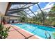 Relax by the sparkling in-ground pool surrounded by a screened enclosure and lush greenery at 2924 Windridge Dr, Holiday, FL 34691