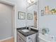 Bathroom featuring a sink vanity, toilet and a mirror with artwork above the toilet at 312 Barrington Ct, Spring Hill, FL 34609