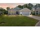 Evening shot of house with manicured front lawn, patterned driveway and inviting exterior lighting at 312 Barrington Ct, Spring Hill, FL 34609