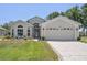 Charming home featuring a well-manicured lawn, a two-car garage, and attractive landscaping at 312 Barrington Ct, Spring Hill, FL 34609
