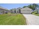 Charming home featuring a well-manicured lawn, a two-car garage, and attractive landscaping at 312 Barrington Ct, Spring Hill, FL 34609