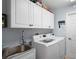 Bright laundry room with stainless steel sink, cabinets, and modern washer and dryer at 312 Barrington Ct, Spring Hill, FL 34609