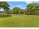 Spacious backyard lawn featuring mature trees, offering plenty of room for outdoor activities at 3431 Saturn Rd, Brooksville, FL 34604