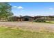 Exterior view of barn featuring covered paddocks with wooden fencing and beautiful landscaping at 3431 Saturn Rd, Brooksville, FL 34604