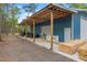 Side view of blue barn featuring a large covered parking area for tractors and equipment at 3431 Saturn Rd, Brooksville, FL 34604