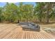 Stylish outdoor deck featuring a modern sectional sofa for comfortable lounging surrounded by lush trees and serene nature at 3431 Saturn Rd, Brooksville, FL 34604