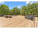 Large wood deck with dining and lounging, perfect for outdoor gatherings and relaxation amidst a serene wooded setting at 3431 Saturn Rd, Brooksville, FL 34604