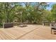 Well-equipped wood deck with grill, picnic table, and dining area, perfect for outdoor meals surrounded by natural beauty at 3431 Saturn Rd, Brooksville, FL 34604