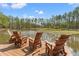 Wooden dock featuring chairs and fishing poles, ideal for lakeside recreation and relaxation at 3431 Saturn Rd, Brooksville, FL 34604
