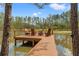 Waterfront dock with four wooden chairs, perfect for relaxing and enjoying nature at 3431 Saturn Rd, Brooksville, FL 34604