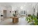 Bright, open foyer with a glass staircase, decorative butterfly, chandelier, and beautifully designed glass-accented front doors at 3431 Saturn Rd, Brooksville, FL 34604