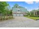 Three-car garage with a metal roof and long driveway, offering ample parking and storage at 3431 Saturn Rd, Brooksville, FL 34604
