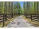 Private gated entrance with fencing and mature trees, providing security and a grand sense of arrival at 3431 Saturn Rd, Brooksville, FL 34604