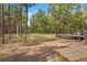 Expansive property showcasing a lush, green field with towering trees and farm equipment at 3431 Saturn Rd, Brooksville, FL 34604