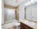 Bathroom with a toilet, vanity with a sink, and a shower-tub combination enclosed by a decorative glass door at 4321 High Ridge Ave, Spring Hill, FL 34609