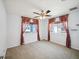 Bedroom with neutral carpet, ceiling fan, and windows with decorative curtains at 4321 High Ridge Ave, Spring Hill, FL 34609