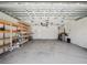 This is a white garage with concrete floor, shelving on the left, and mechanicals along the back wall at 4321 High Ridge Ave, Spring Hill, FL 34609
