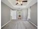 Main bedroom with carpet, ceiling fan, trey ceiling, and view into the main bath at 4321 High Ridge Ave, Spring Hill, FL 34609