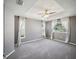 Large main bedroom with tray ceiling, carpet floors, and natural light from multiple windows at 4321 High Ridge Ave, Spring Hill, FL 34609