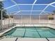 Screened-in pool with clear blue water on a sunny day at 4321 High Ridge Ave, Spring Hill, FL 34609