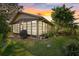 Exterior view of home's lanai, landscaping, and lush green lawn at sunset at 4504 Dewey Dr, New Port Richey, FL 34652