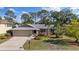 Charming single-Gathering home featuring a manicured lawn, mature trees, and an attached two-car garage at 4504 Dewey Dr, New Port Richey, FL 34652