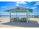 Scenic picnic area on the beach with picnic tables beneath a shaded shelter overlooking the ocean at 4504 Dewey Dr, New Port Richey, FL 34652
