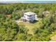 Aerial view of a two-story home featuring a metal roof, dual decks, and lush, tropical landscaping at 4514 Fishman Ave, Weeki Wachee, FL 34607