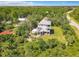An aerial shot shows a two-story home with a metal roof, dual decks, and lots of lush, surrounding greenery at 4514 Fishman Ave, Weeki Wachee, FL 34607