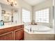 Bright bathroom features a soaking tub with tiled surround and glass block windows for natural light at 4514 Fishman Ave, Weeki Wachee, FL 34607