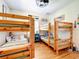 This large bedroom is equipped with hardwood floors and three sets of bunkbeds at 4514 Fishman Ave, Weeki Wachee, FL 34607