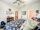 Comfortable bedroom featuring a floral comforter, neutral walls, ceiling fan, and adjoining door to a bathroom at 4514 Fishman Ave, Weeki Wachee, FL 34607