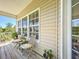 Cozy front porch with wooden floors, comfortable seating, and a view of the surrounding landscape at 4514 Fishman Ave, Weeki Wachee, FL 34607