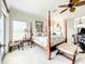 Serene main bedroom features a four-poster bed, ceiling fan, and neutral carpet flooring at 4514 Fishman Ave, Weeki Wachee, FL 34607