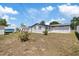 Backyard with white exterior and privacy fence; features grassy areas, and a storage shed, offering a private outdoor space at 4607 Kennedy Dr, New Port Richey, FL 34652