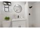 Updated bathroom featuring a modern vanity, round mirror, and walk-in shower with rainfall showerhead at 4607 Kennedy Dr, New Port Richey, FL 34652