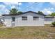 Rear exterior view highlighting the clean white siding, windows, and a door, complemented by a grassy area at 4607 Kennedy Dr, New Port Richey, FL 34652