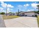 Charming single-story home with a well-manicured lawn, a long driveway, and an attached garage, showcasing curb appeal at 4607 Kennedy Dr, New Port Richey, FL 34652