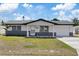 Charming single-story home featuring a dark brick facade, well-maintained lawn, and attached garage at 4607 Kennedy Dr, New Port Richey, FL 34652