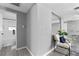 Hallway view leading to the bathroom with a chair and plant creating a bright, airy space at 4607 Kennedy Dr, New Port Richey, FL 34652
