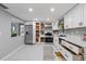 Bright kitchen features stainless steel appliances, white cabinets, and tile flooring at 4607 Kennedy Dr, New Port Richey, FL 34652