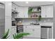 Well-lit kitchen with white cabinets, stainless steel appliances, and stylish decorative elements on the backsplash at 4607 Kennedy Dr, New Port Richey, FL 34652