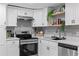 Close-up on stainless steel oven and decorative shelving in kitchen with white cabinetry at 4607 Kennedy Dr, New Port Richey, FL 34652
