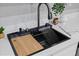Close-up of a modern kitchen sink with a cutting board and a sleek faucet, blending style and functionality at 4607 Kennedy Dr, New Port Richey, FL 34652