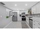 Bright kitchen features stainless steel appliances, white cabinets, and tile flooring at 4607 Kennedy Dr, New Port Richey, FL 34652