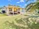 Backyard with covered patio, a dining set, barbeque grill, and mature palm trees at 5128 Perennial Dr, Holiday, FL 34690