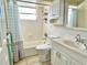Bathroom features a shower-tub combo, white tile, and a vanity with a sink and cabinetry at 5128 Perennial Dr, Holiday, FL 34690