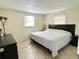 Bedroom features tile floors, a dark bed frame, and two windows offering natural light at 5128 Perennial Dr, Holiday, FL 34690