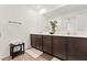 Bathroom featuring double vanity sinks, dark cabinets, wood flooring and a large mirror at 5383 Companion Ln, Tampa, FL 33619
